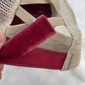 Close-up of ponytail cap's back mesh and red velcro adjustable strap
