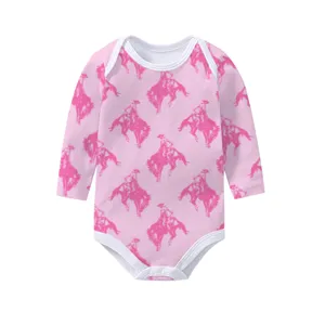 Close-up detail of pink long sleeve baby bodysuit with repeating cowboy horse pattern