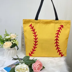 Detail of yellow canvas tote bag with distinctive red baseball stitch pattern.