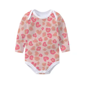 Detailed macro view of pink heart-leopard print on soft cotton long-sleeved baby bodysuit