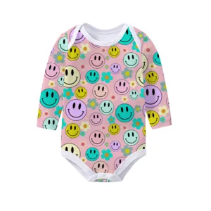 Detail view of pink baby long sleeve romper with vibrant colorful smiley face prints
