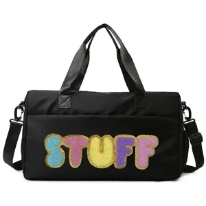 Detailed front view of a black sports bag featuring colorful fuzzy STUFF lettering