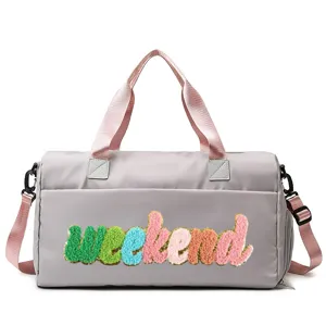 Stylish grey sports duffel bag with colorful weekend chenille patch and pink straps