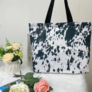 Large capacity canvas tote bag featuring a stylish black and white cow print pattern