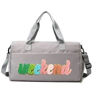 Detailed view of grey sports gym bag featuring colorful weekend chenille patch design