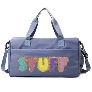 Close-up detail of a purple sports fitness bag featuring colorful STUFF fleece letter patches