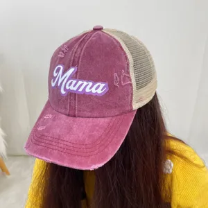 Close-up of a distressed purple Mama print ponytail trucker hat worn by a model