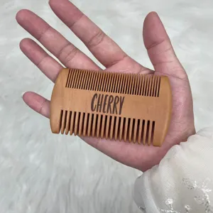 Peine para barba personalizado de bambú con grabado 'CHERRY' sostenido en la mano