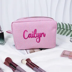 Detailansicht der rosa gestreiften Seersucker-Kosmetiktasche mit Stickerei