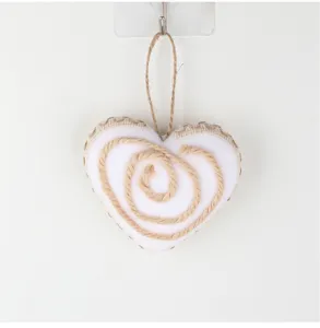 Detalle de colgante de cuerda de yute en forma de corazón, adorno rústico para árbol de Navidad.