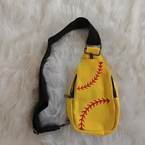 Detailed view of a yellow canvas chest bag with vibrant red baseball stitch embroidery