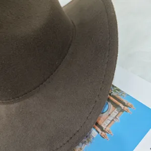 Close-up of brown felt cowboy hat brim with detailed stitching on white fur background