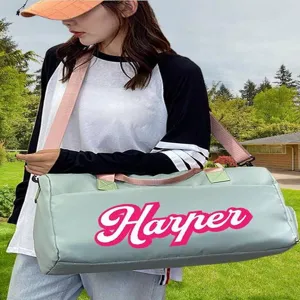 Detail view of a customized light green sports bag with personalized 'Harper' text