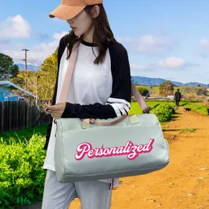 Large light green fitness bag with custom pink personalized text carried outdoors