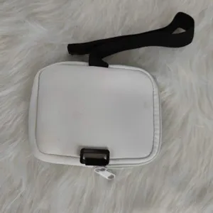 Close-up detail of a white neoprene accessory pouch with black straps for 40oz tumblers.