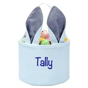 Close-up of a personalized striped Easter bucket with embroidered name and bunny ears.