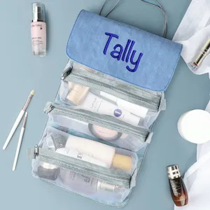 Detailansicht der blauen Denim-Kosmetiktasche mit personalisierter Tally-Stickerei