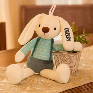 Detail view of a plush white rabbit featuring custom black name embroidery on its soft ear.