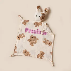 Close-up of baby security blanket featuring embroidered pink name and cute bear prints