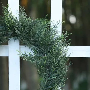 Dettaglio ghirlanda pino cipresso finto, corona foglie PE verdi per decorazione porta esterna.