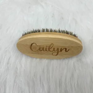 Primer plano de cepillo para barba de bambú personalizado con cerdas y nombre grabado