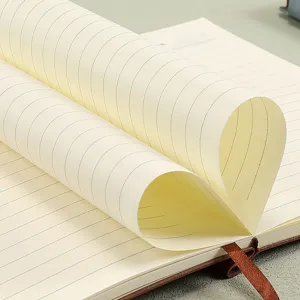 Close-up of A5 notebook showing high-quality lined pages curled into a heart shape.