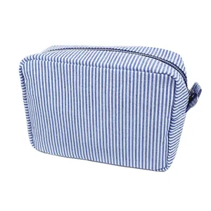 Detailansicht einer blau-weiß gestreiften Seersucker-Kosmetiktasche mit Reißverschluss