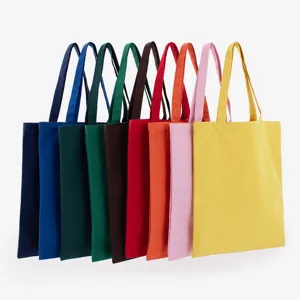 Detailed view of multiple colorful solid canvas tote bags arranged in a row