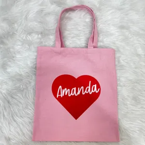 Close-up of pink canvas tote bag featuring a red heart and custom 'Amanda' name