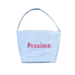 Detail of blue striped seersucker Easter basket with pink Proxima name embroidery