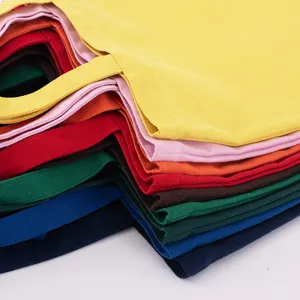Detail view of stacked colorful canvas tote bags showing fabric texture and vibrant hues.
