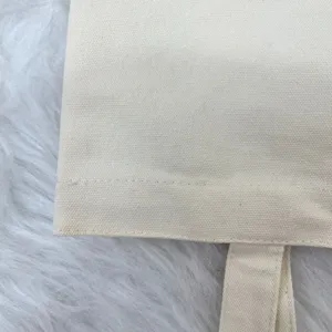 Macro view showing the durable canvas fabric texture and stitching of a plain tote bag