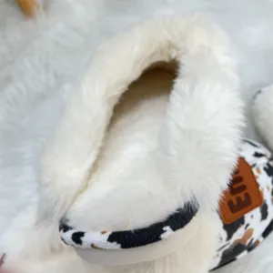 Close-up view of warm Western-style plush slipper with cow print and thick fur lining
