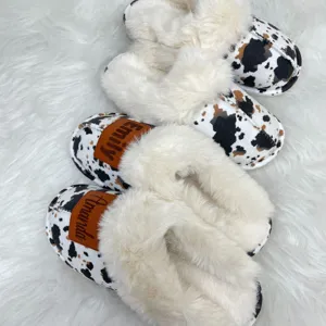 Detailed close-up of custom western style cow print slippers with plush faux fur lining