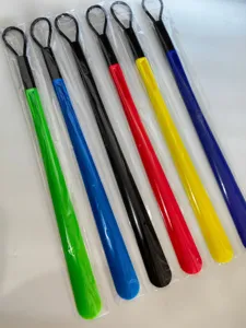 Detail shot of colorful long plastic shoe horns with hanging loops, individual packaging.