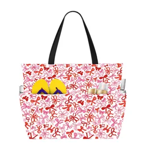Detailed view of a large waterproof beach bag with red bow pattern showing storage capacity