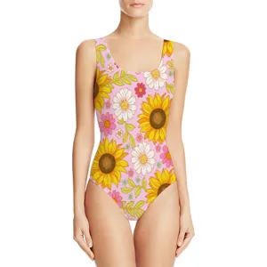 Detail view of one-piece swimsuit with vibrant sunflower and daisy print on pink background