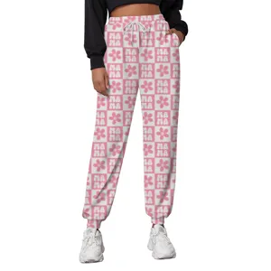 Detail of pink and white checkered sweatpants with MAMA and flower print for casual style.