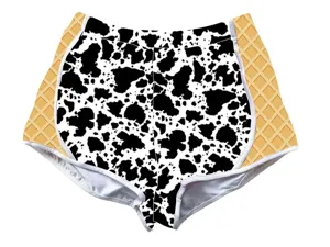 Detailed front view of cow print shorts with waffle cone pattern side panels for women