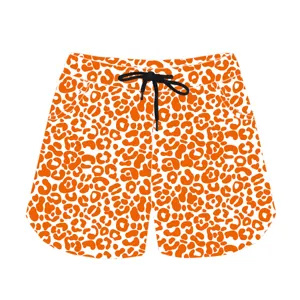 Detailed view of casual sports shorts featuring vibrant orange leopard print and black drawstring
