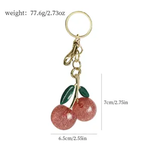 Vue détaillée du porte-clés cerise avec indications de taille et de poids sur blanc