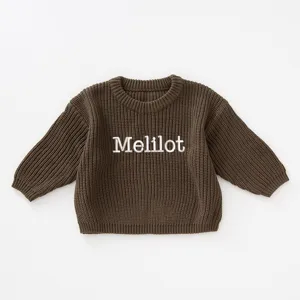 Close-up detail of children's brown chunky knit sweater with custom Melilot embroidery