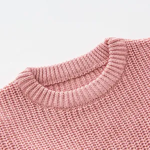 Close-up of pink crew neck knitted sweater for girls with chunky texture and ribbed collar