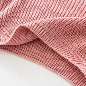 Close-up of pink knit sweater texture showing detailed ribbed hem and soft fabric