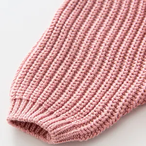 Close-up view of a soft pink knit sweater cuff featuring fine textured ribbed weave detail