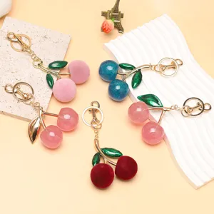 Variété de porte-clés cerise en velours et paillettes pour décorer les sacs
