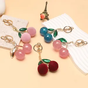 Vue détaillée de porte-clés en forme de cerise aux finitions et couleurs variées