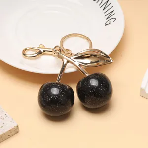 Vue détaillée d'un porte-clés cerise noire avec feuille d'or et finition scintillante