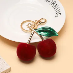 Vue détaillée d'un porte-clés cerise de luxe avec finition en velours rouge et métal doré
