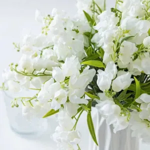 Détail d'arrangement de fleurs de muguet artificiel, fausses plantes déco maison.